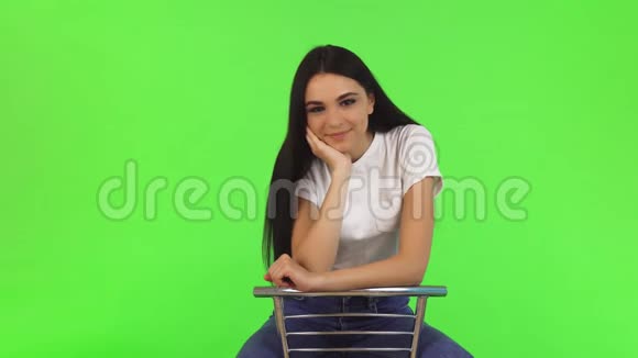 漂亮快乐的少女坐在椅子上对着镜头微笑视频的预览图