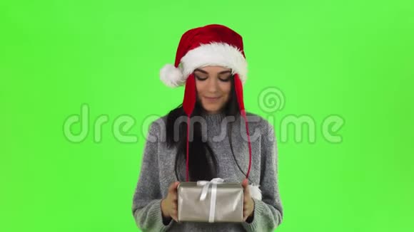 美丽的圣诞女孩微笑着拿出圣诞礼物送给相机视频的预览图