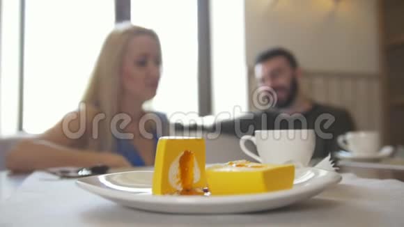 一对夫妇坐在咖啡馆里吃甜甜点喝着咖啡笑着视频的预览图