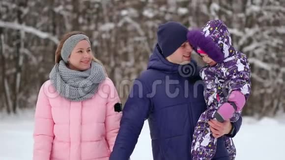 日落时幸福的家庭爸爸妈妈和两个女儿玩得很开心在下雪的冬天散步视频的预览图