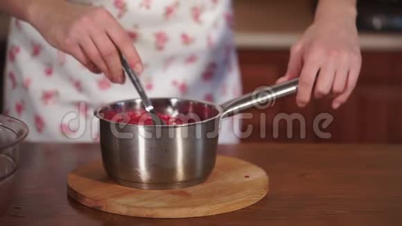靠近一个带有水果糖浆的平底锅用勺子搅动厨师视频的预览图