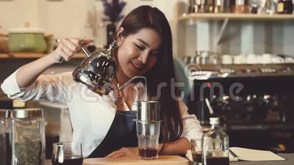 亚洲专业女咖啡师在自助餐厅柜台酒吧做咖啡作为店主女服务员在做视频的预览图