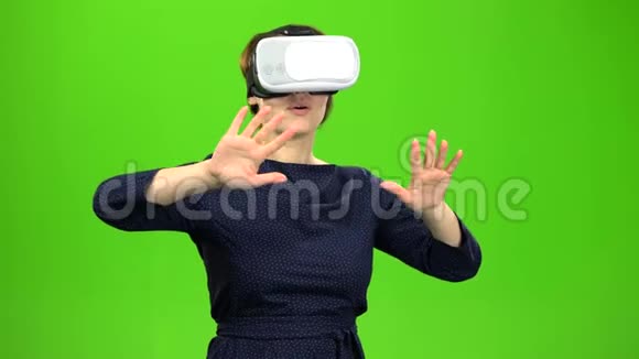 戴着虚拟眼镜的女人正在看一部有趣的电影绿色屏幕视频的预览图