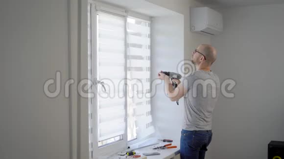 一个雇员在一间新建的公寓里做了一个小时的小修理他把窗帘挂在窗帘上视频的预览图