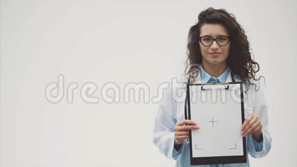微笑的女医生与文件夹在一个单一的立场微笑的女人医生在这期间她穿着灰色的视频的预览图