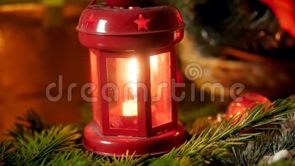 在圣诞树树枝上用燃烧的蜡烛拍摄红色灯笼的特写镜头冬天的完美背景视频的预览图