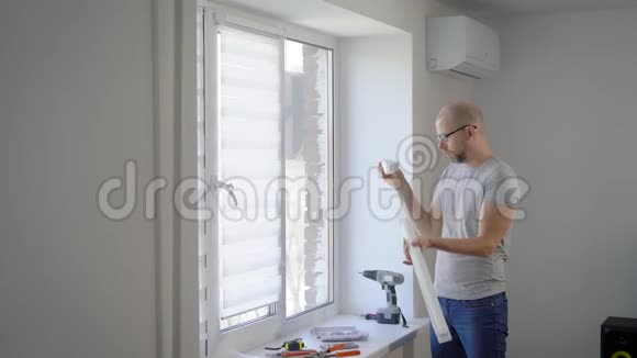 一个成年人在他的公寓里修理那个人打开挂在窗户上的窗帘视频的预览图