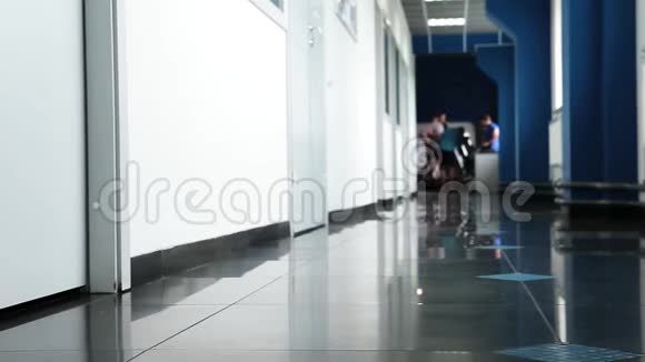 穿着黑色鞋子的年轻女子在黑色大理石地板上沿着走廊行走视频的预览图