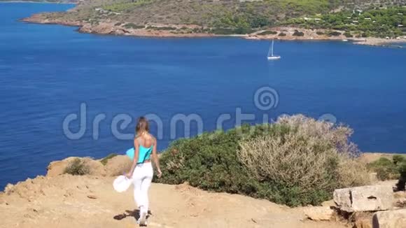 女孩走在山上俯瞰大海视频的预览图
