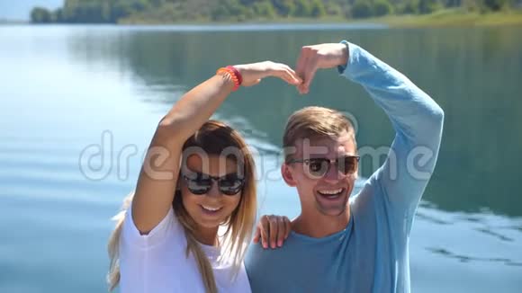 年轻的一对坐在船头在阳光明媚的日子里摆成相机快乐的一对相爱的情侣在一起视频的预览图