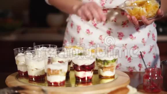 厨师把一些水果放进杯子里用桔子装饰奶油视频的预览图