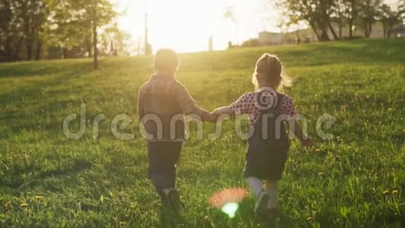 日落时分小男孩和小女孩一起沿着夏野散步视频的预览图