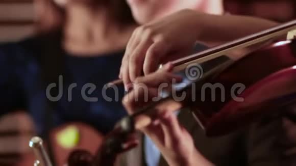 拉小提琴的女孩的手弓沿着弦移动提取音乐视频的预览图