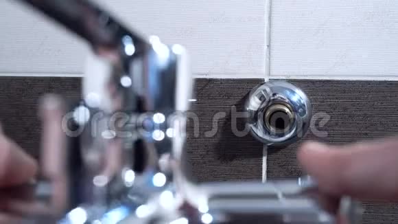 水管工在浴室里安装了一个搅拌器龙头他正坐在浴缸里特写镜头视频的预览图