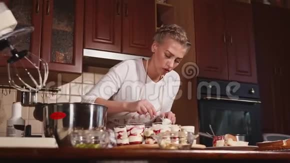 一位年轻女士在厨房准备甜点女士用杯子把糖果吃完视频的预览图