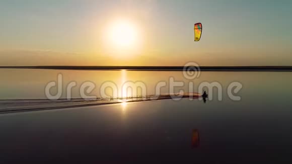 侧面看一个人漂浮在湖面上驾驶着一只大型训练风筝视频的预览图
