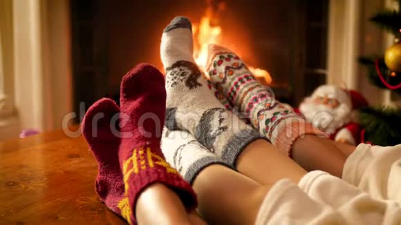 圣诞前夜一家人穿着温暖的羊毛袜子坐在壁炉旁的4k视频视频的预览图