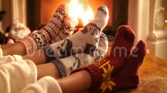 圣诞前夜一家人带着孩子穿着暖毛袜躺在壁炉旁的特写4k视频视频的预览图