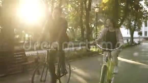 白人年轻夫妇或朋友骑自行车在空荡荡的城市公园或林荫大道在夏天人休闲视频的预览图