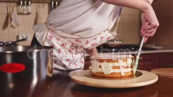 在抹刀的帮助下把奶油放到蛋糕上的厨师手的特写镜头视频的预览图