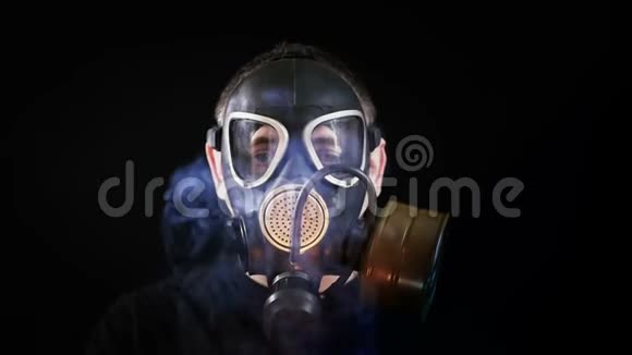 黑色背景下戴防毒面具的人的脸在一个人周围抽烟视频的预览图