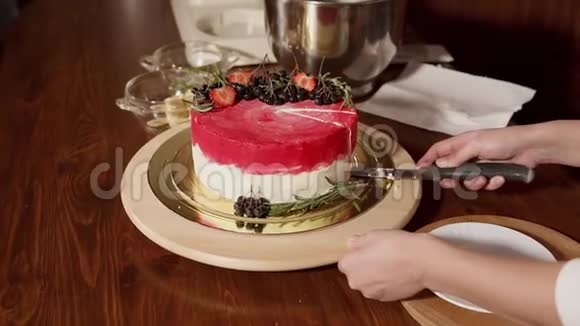 一个女人切一块甜蛋糕然后把一片放在盘子里视频的预览图