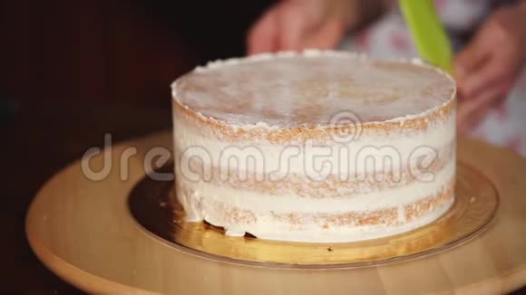 把蛋糕上的沙糕贴紧厨师在蛋糕上涂上奶油视频的预览图
