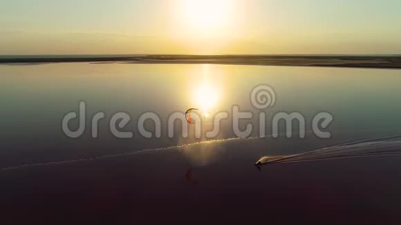 黎明时分橙色训练风筝在平静的湖面上慢动作视频的预览图
