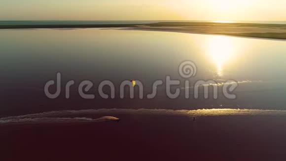 在浅粉色的湖上进行风筝冲浪从顶部观看视频的预览图