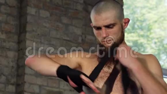 有胡子的男拳击手在战斗前包住他的指节视频的预览图