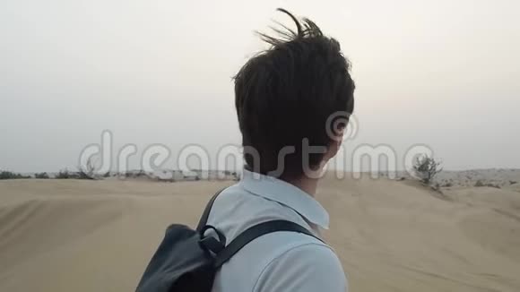 年轻人在沙漠里旅游风暮色视频的预览图