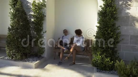 一对老夫妇坐在长凳上享受日落视频的预览图