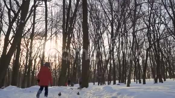 男孩在冬季公园里慢动作奔跑视频的预览图