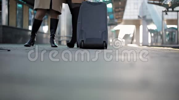 一个女人带着手提箱在车轮上发生在一个铁路站台上等待火车视频的预览图