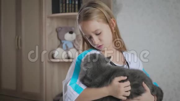 小女孩在家和猫玩医生女孩扮演兽医与家庭宠物视频的预览图