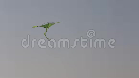 一只绿色的风筝在蓝天上飞翔视频的预览图