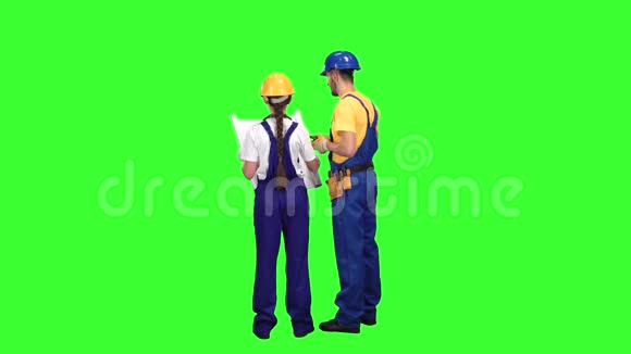 两个建筑工人背靠背站着看着时间表绿色屏幕视频的预览图