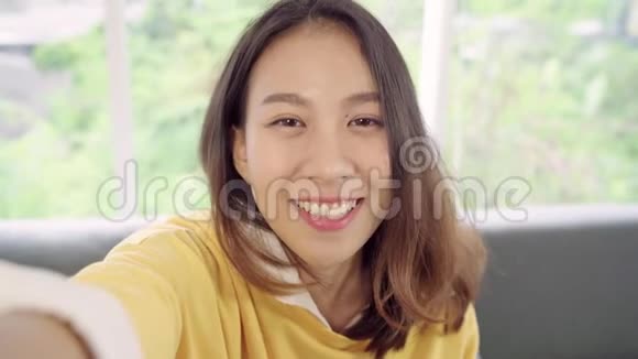 亚洲博客女性使用智能手机录制vlog视频在家客厅视频的预览图