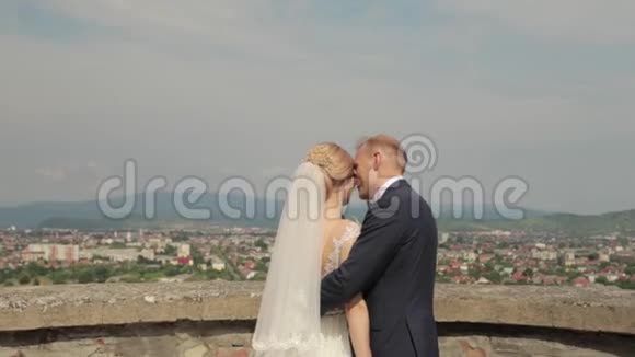穿着婚纱的男人和女人站在城市景色的城堡里视频的预览图