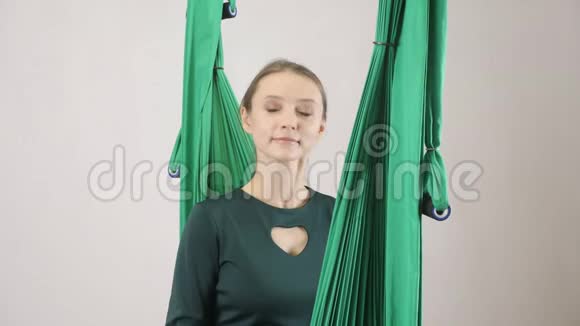 年轻女子坐在吊床上摇着头说不空中航空飞行健身教练训练冥想和谐视频的预览图