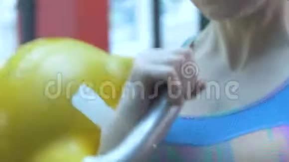 女孩在健身房举起金属重量和皱眉努力视频的预览图