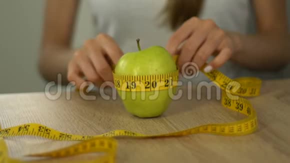 女人用胶带线测量苹果计算卡路里体重指数视频的预览图