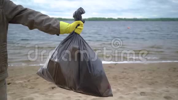 义工手拿沙滩垃圾袋视频的预览图