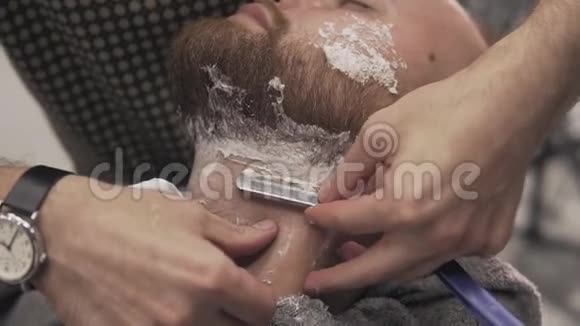 理发店里用直剃刀刮胡子的男人男性护肤理念视频的预览图