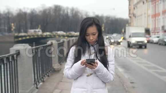 亚洲年轻女子行走手机智能手机视频的预览图
