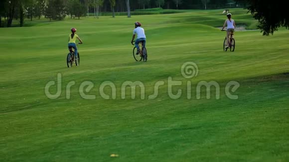 一群朋友骑自行车在绿草上视频的预览图