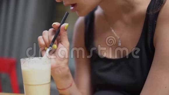 那个年轻漂亮的女人在酒吧里喝奶昔视频的预览图