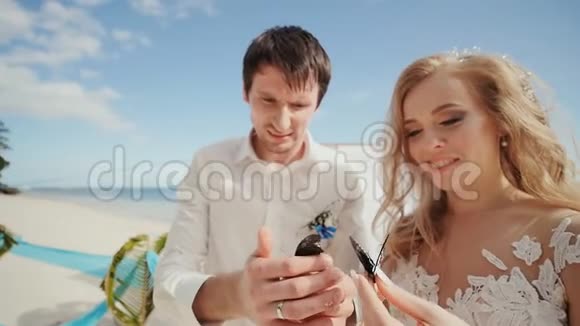 新婚夫妇新郎和新娘一起在他们的手中是美丽的画蝴蝶令人难以置信的神奇视频的预览图