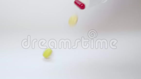 关闭医疗药片药片胶囊和药物落入白色桌子视频的预览图