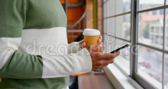 商务人员在办公室用手机喝咖啡视频的预览图